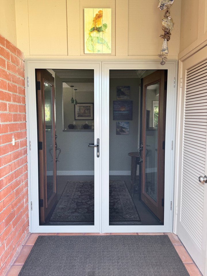White-framed French security doors installed across a home entry
