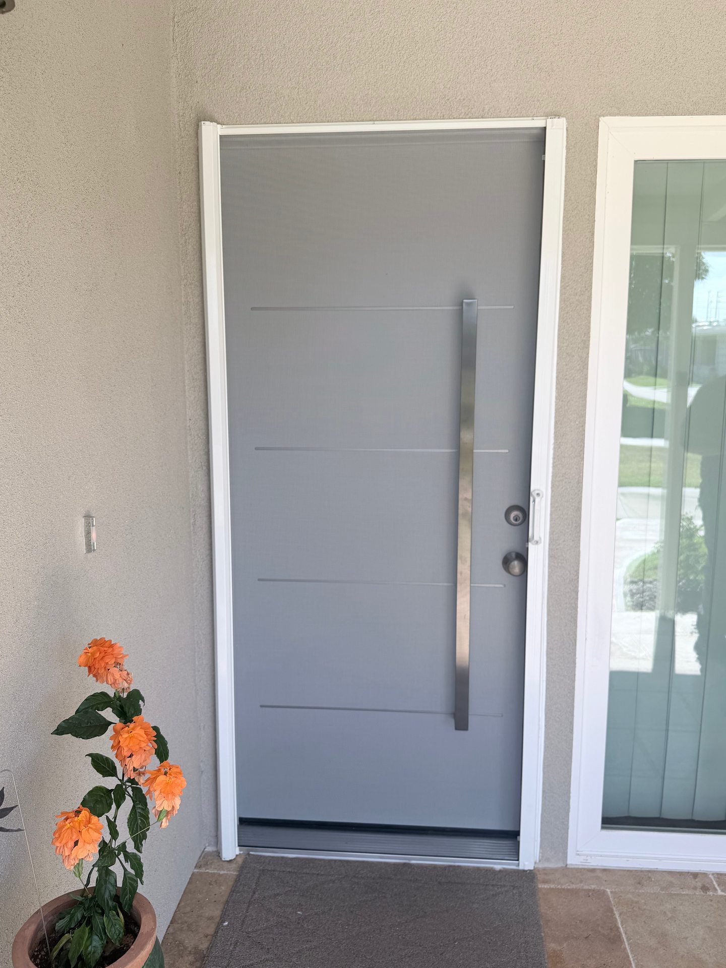 White retractable screen extended across a modern entry door