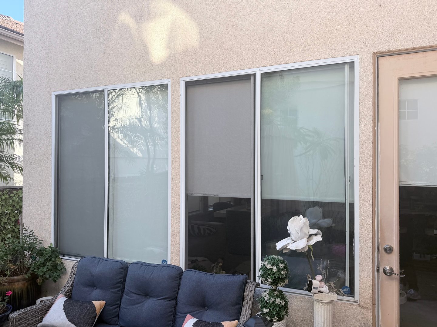 Window screens fitted to two windows overlooking a covered patio