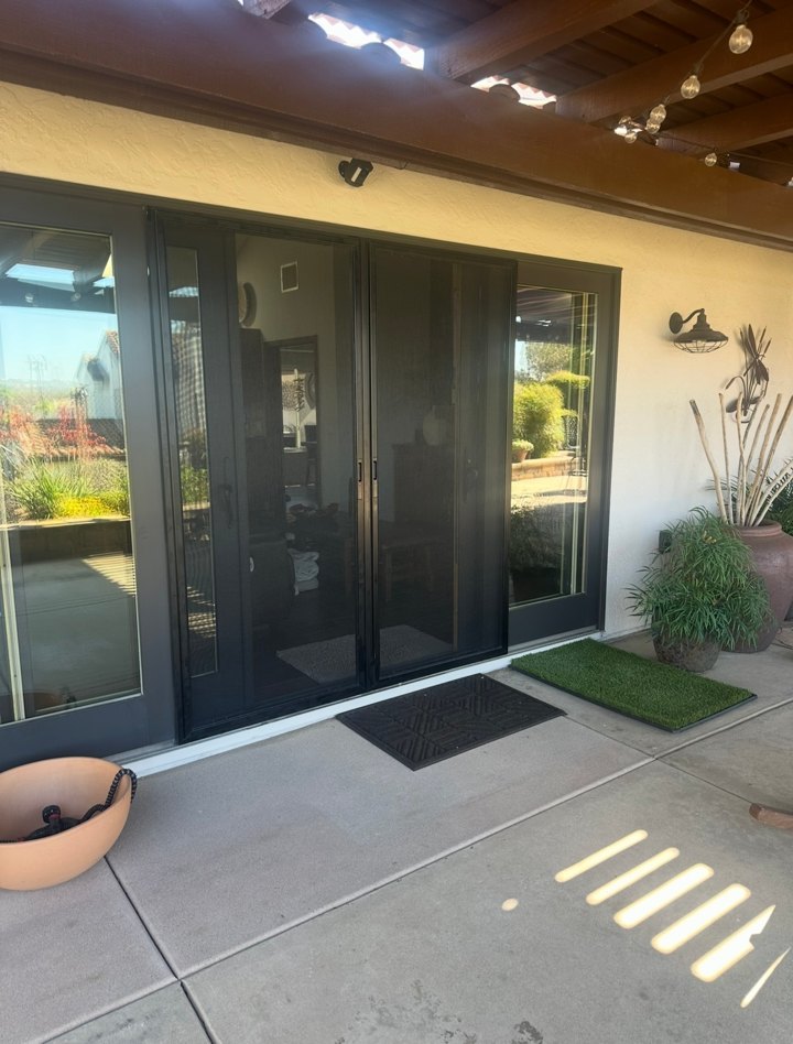 Double sliding screen doors at a covered patio