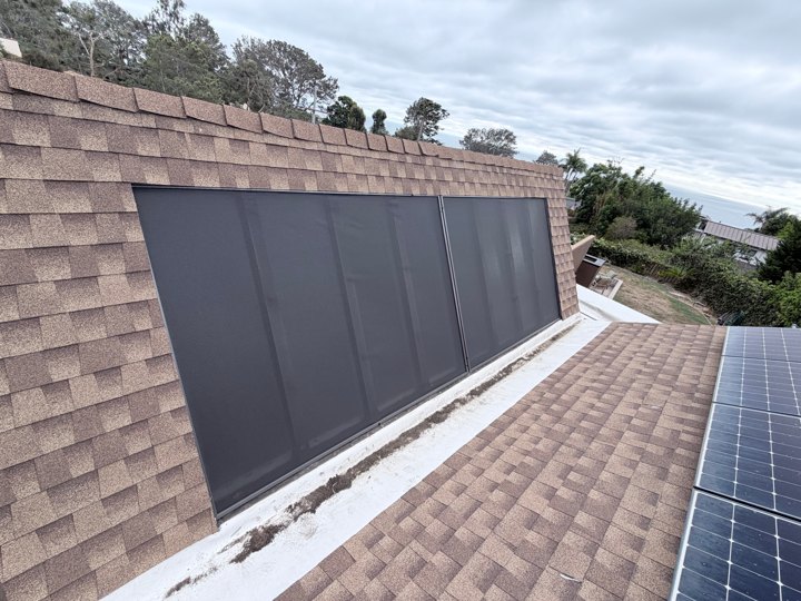 Exterior solar window screens fitted over a row of upper-story windows
