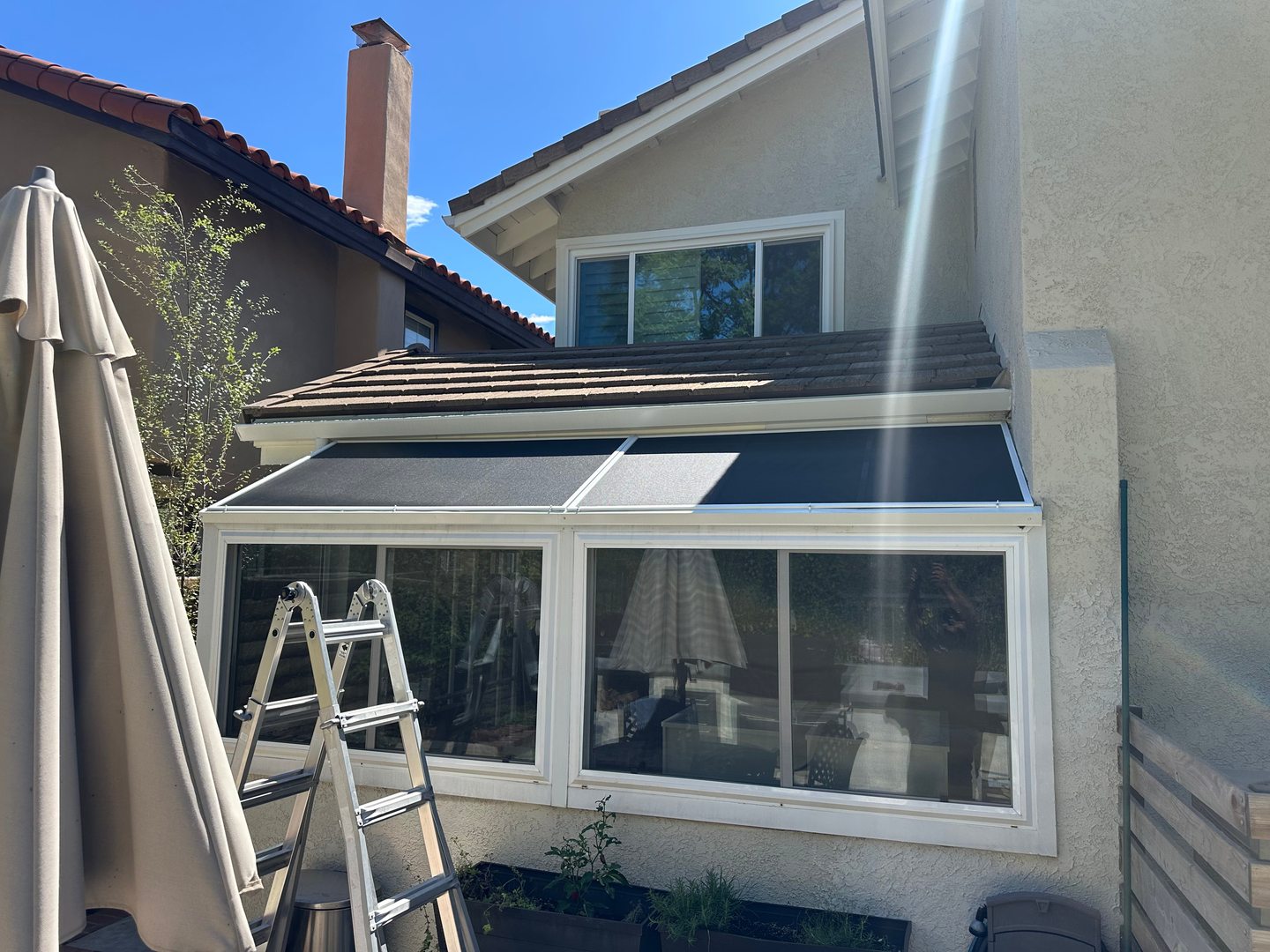 Solar screens fitted over sloped sunroom glass