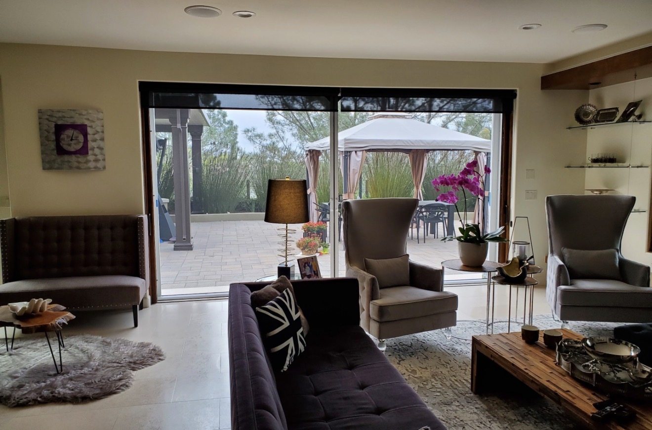 Interior view of retractable screens across a wide living-room opening
